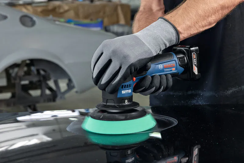 บุคคลที่สวมอุปกรณ์ความปลอดภัยกำลังขัดผิวรถด้วยเครื่องขัดแบบไร้สาย.