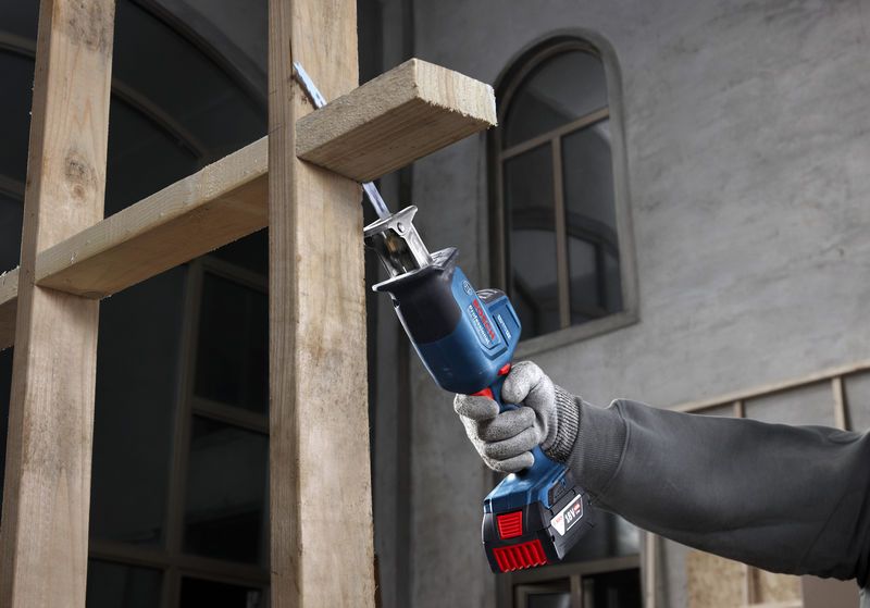 บุคคลที่สวมอุปกรณ์ด้านความปลอดภัยใช้เลื่อยตัดไม้แบบลูกสูบ.