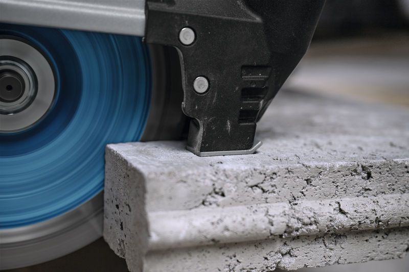 เครื่องเจียรขนาดใหญ่ตัดผ่านแผ่นคอนกรีตหนา.