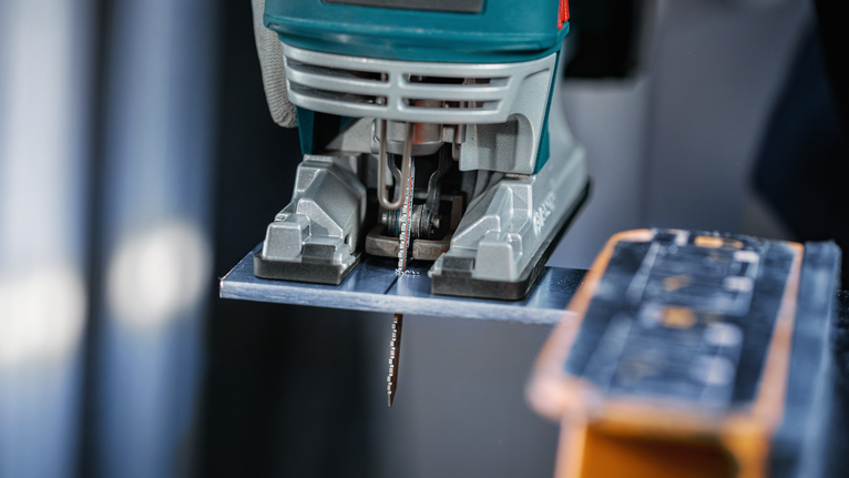 จิ๊กซอว์ตัดแผ่นโลหะบนโต๊ะทำงาน