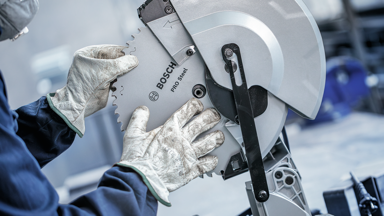 บุคคลที่สวมอุปกรณ์ความปลอดภัยกำลังปรับใบเลื่อยวงเดือน