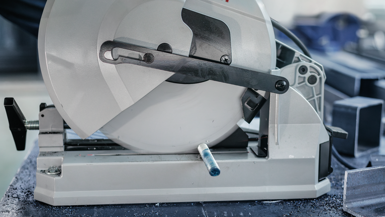 ใบเลื่อยตัดโลหะวางอยู่ข้างๆ แท่งเหล็กทำมุมหลายอัน