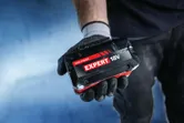 แบตเตอรี่ Bosch Expert 18V ในมือที่สวมถุงมือ.