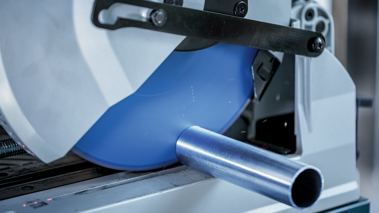 การตัดท่อโลหะด้วยเลื่อยวงเดือนในโรงงานอุตสาหกรรมแบบใกล้ชิด.