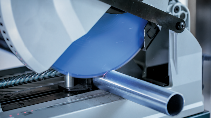 เลื่อยตัดโลหะใช้ตัดท่อโลหะกลมและมีประกายไฟออกมา.