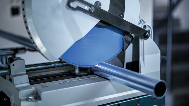 ใบเลื่อยตัดโลหะกำลังเลื่อยท่อเหล็กในโรงงาน.