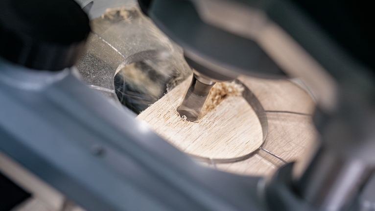 เครื่องมือโรตารี่เจาะรูที่แม่นยำบนแผ่นไม้.