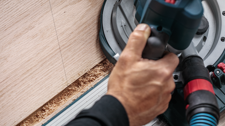 ผู้ใช้เลื่อยวงเดือนตัดไม้ตามแนวเส้นตรง.