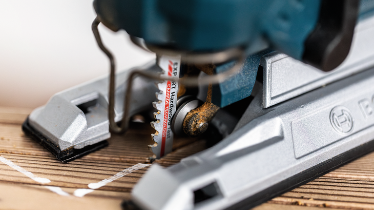 การตัดจิ๊กซอว์ตามเส้นที่ทำเครื่องหมายไว้บนแผ่นไม้.