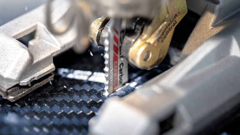 ใบเลื่อยจิ๊กซอว์ตัดผ่านแผ่นคาร์บอนไฟเบอร์.