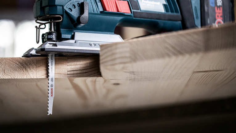 จิ๊กซอว์กำลังตัดแผ่นไม้หนาในโรงงานแห่งหนึ่ง.