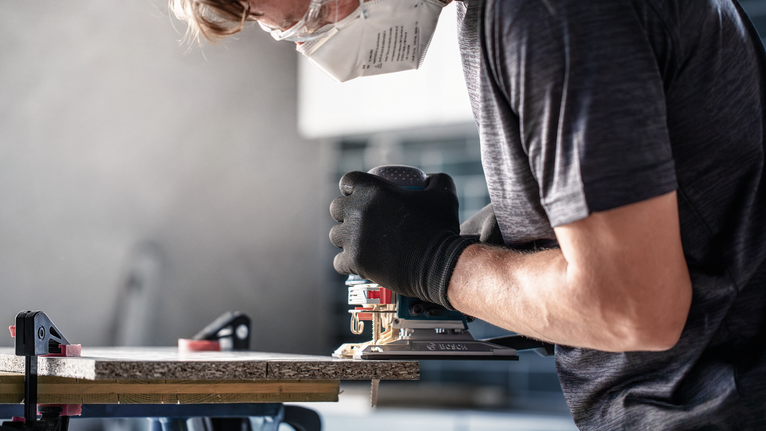 บุคคลที่สวมอุปกรณ์ความปลอดภัยใช้เครื่องมือไฟฟ้าตัดไม้.