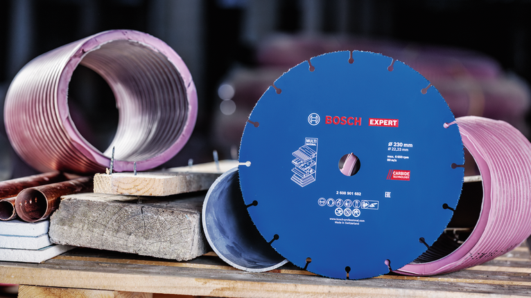 ใบเลื่อยเพชรจัดแสดงอยู่บนโต๊ะทำงานถัดจากตัวอย่างแกนโลหะและคอนกรีต