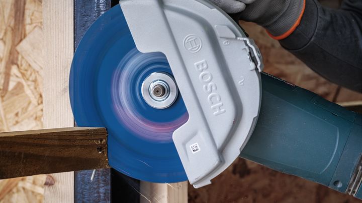 บุคคลที่สวมอุปกรณ์ความปลอดภัยกำลังตัดไม้ด้วยเลื่อยวงเดือน