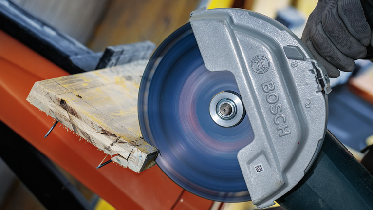 บุคคลที่สวมอุปกรณ์ความปลอดภัยใช้เลื่อยวงเดือนตัดไม้กระดาน