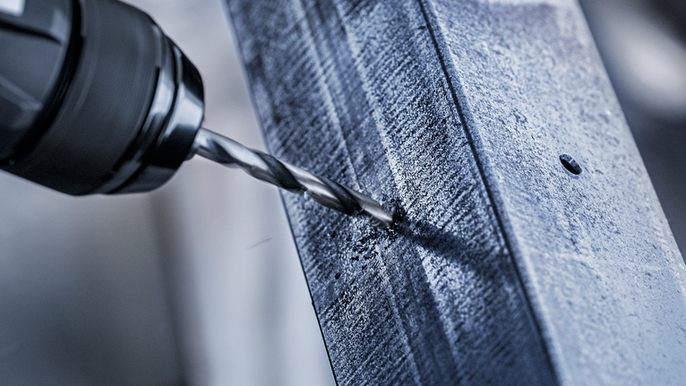 สว่านไฟฟ้าจะสร้างรูบนคานโลหะ