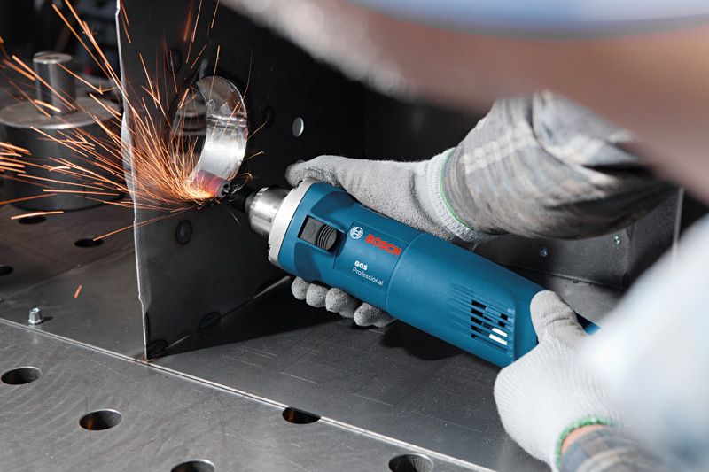 บุคคลที่สวมอุปกรณ์ป้องกันความปลอดภัยกำลังใช้เครื่องมือไฟฟ้าเจียรขอบโลหะ ทำให้เกิดประกายไฟ.