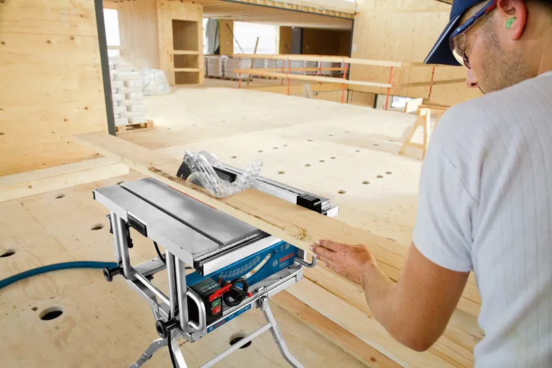 ผู้ชายกำลังใช้เลื่อยโต๊ะ.